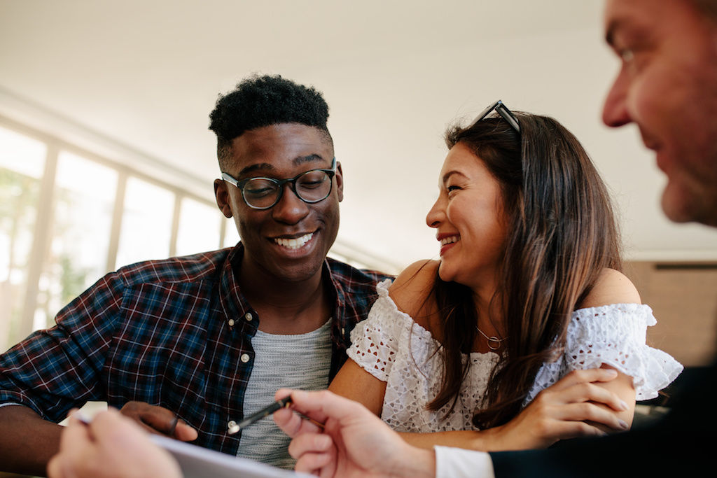 Young man and young woman signing an apartment lease